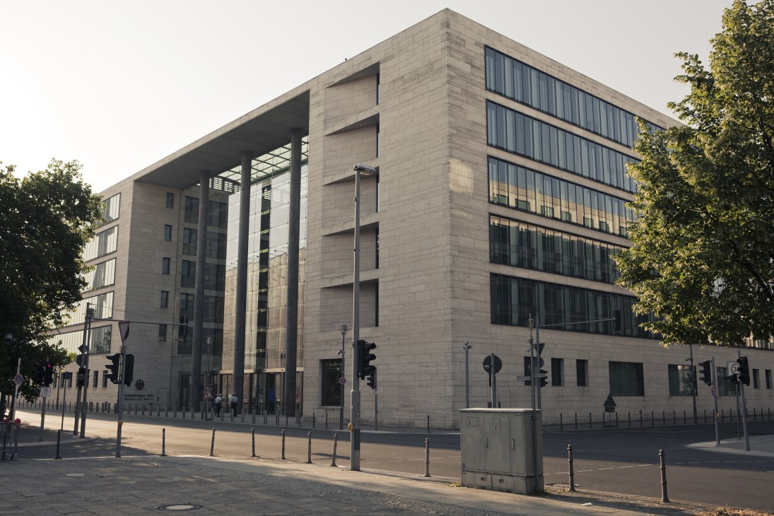 Modern glass and stone building facade of Germany's Foreign Office extension in Berlin with ivy-covered walls.