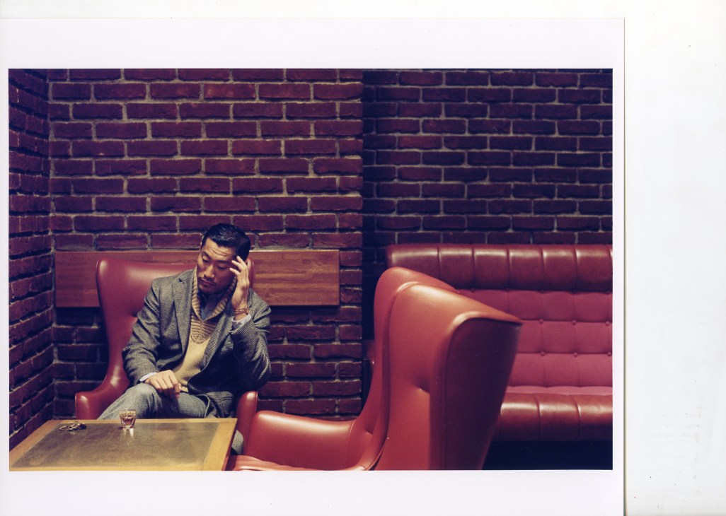 Man seated in red leather armchair at Brillant Bar wearing Loro Piana jacket and Giuliano Fujiwara waistcoat