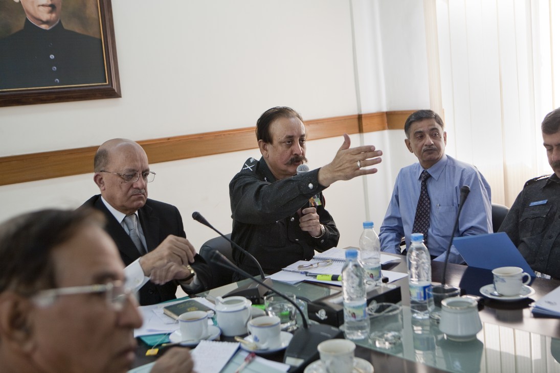 Police chief Waseem Ahmed speaks at a meeting with fellow officers around a conference table.