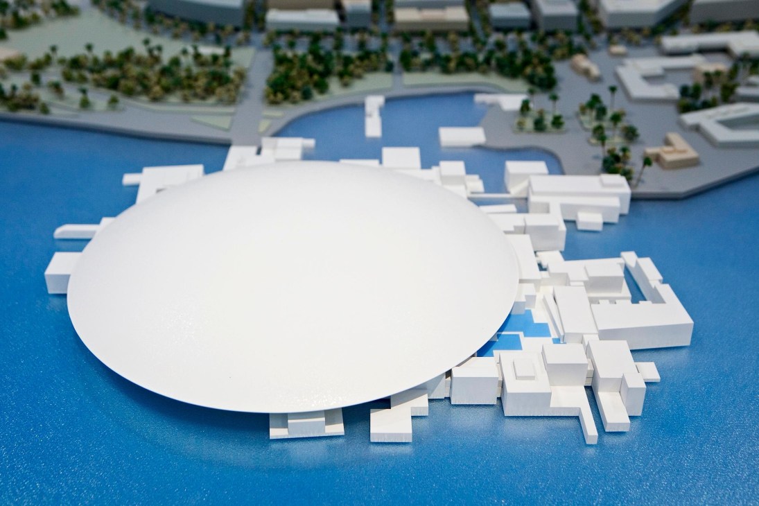 Architectural model of Jean Nouvel's Louvre Abu Dhabi showing white curved and geometric structures on blue water.