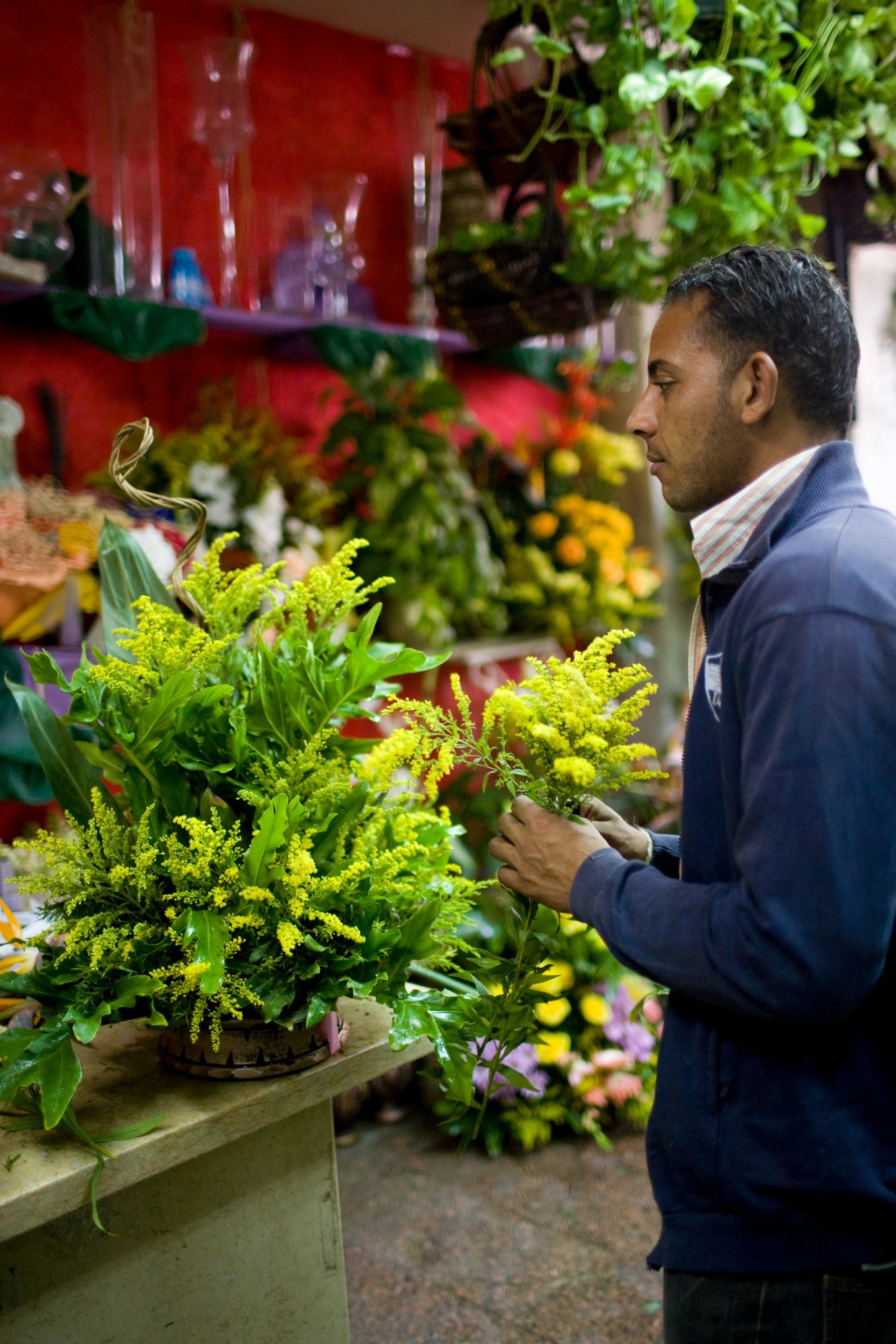 Man selecting yellow flowers at Le Paradis des Fleurs florist shop in Cairo's El Korba neighborhood.