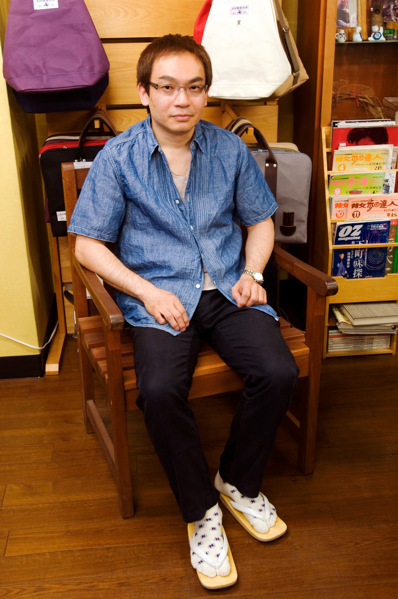 Toshiji Hosokawa, 49-year-old owner of Inujirushi bag company, sits in his Asakusa workshop surrounded by canvas bags.