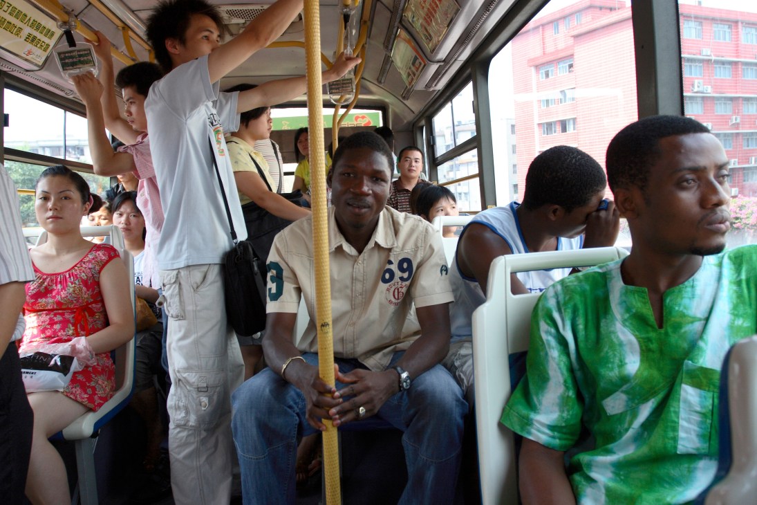 African and Chinese passengers on a crowded bus in Guangzhou, including Kougbadjo Kokou from Togo.
