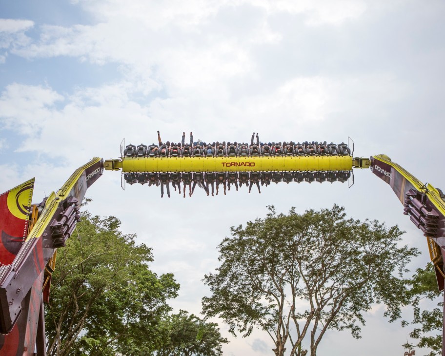 Passengers on Zamperla's yellow Tornado ride experience a tilt-and-flip motion at an amusement park.