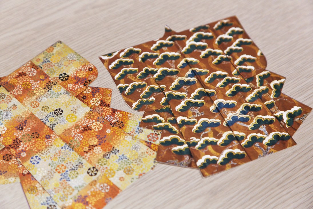 Kimono-shaped postcards with traditional Japanese patterns displayed on a light surface.