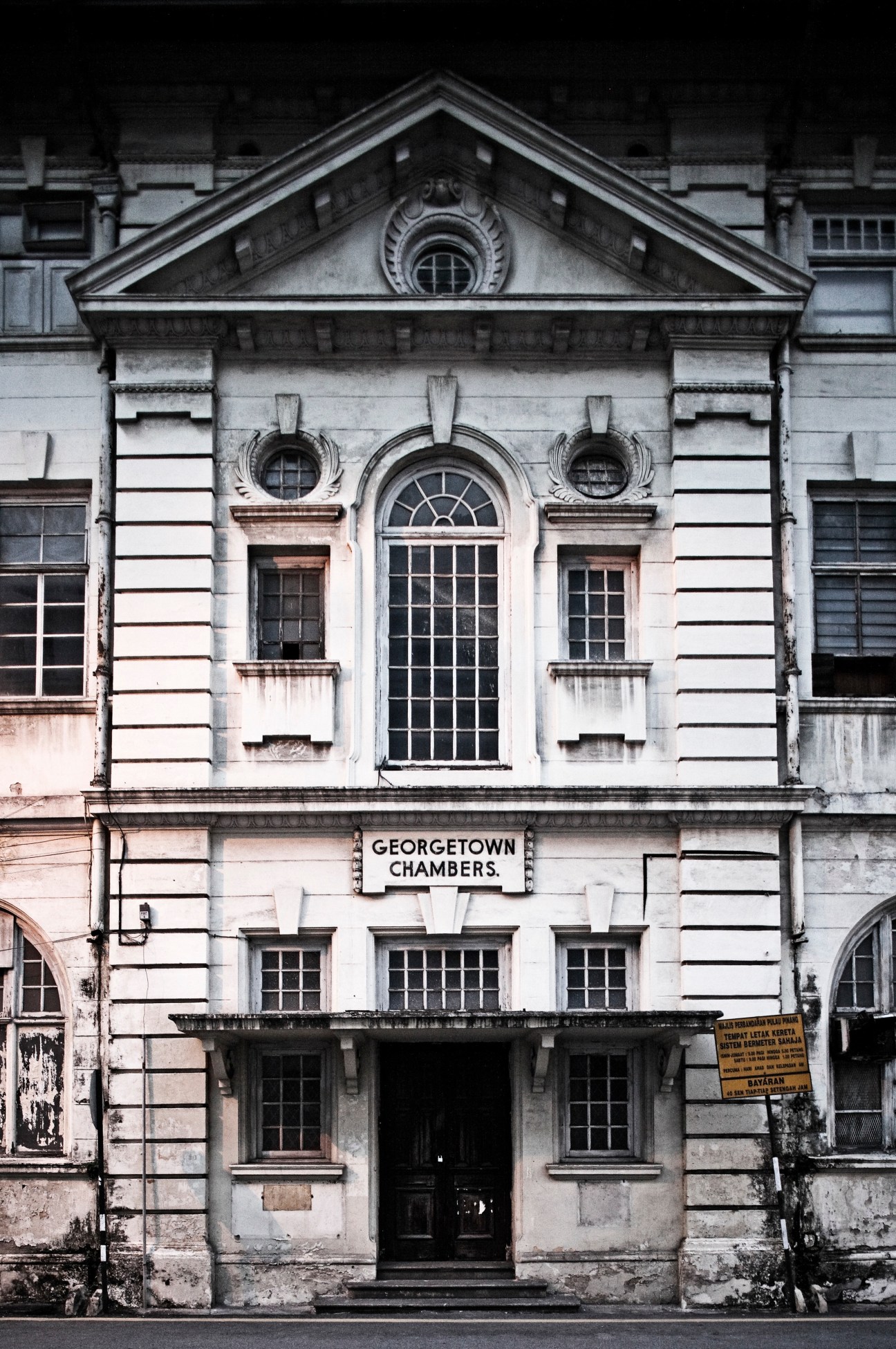 Georgetown Chambers, a weathered colonial building with neoclassical architecture featuring arched windows and symmetrical facade.