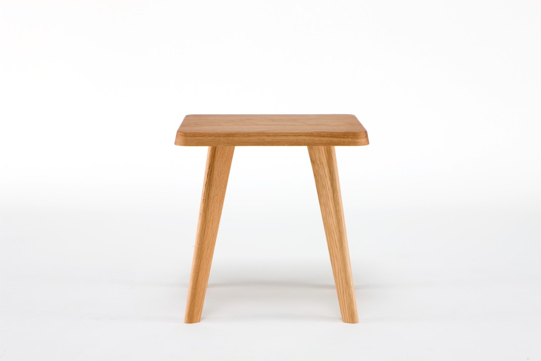 Wooden stool with a rectangular top and four angled legs by Native design house.