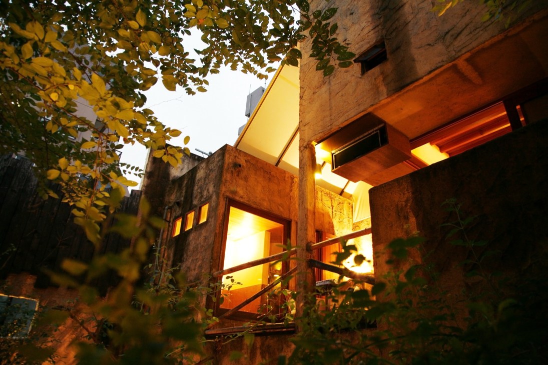 Evening view of Bissori restaurant in Tokyo with illuminated windows and autumn foliage.