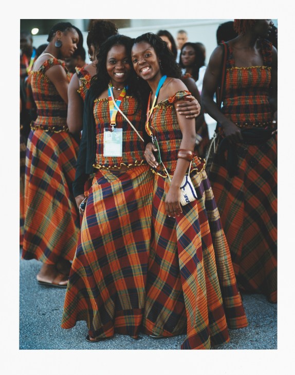 Mozambique team members in colorful patterned traditional dress smile together at the opening ceremony.