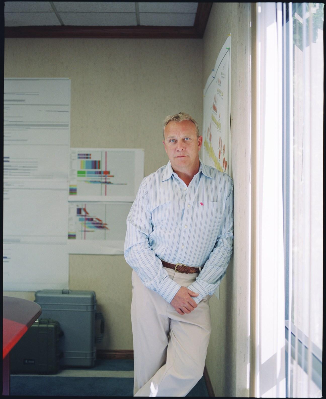 Lyndon Faulkner, Pelican Products CEO, stands in an office hallway wearing a light blue striped shirt.