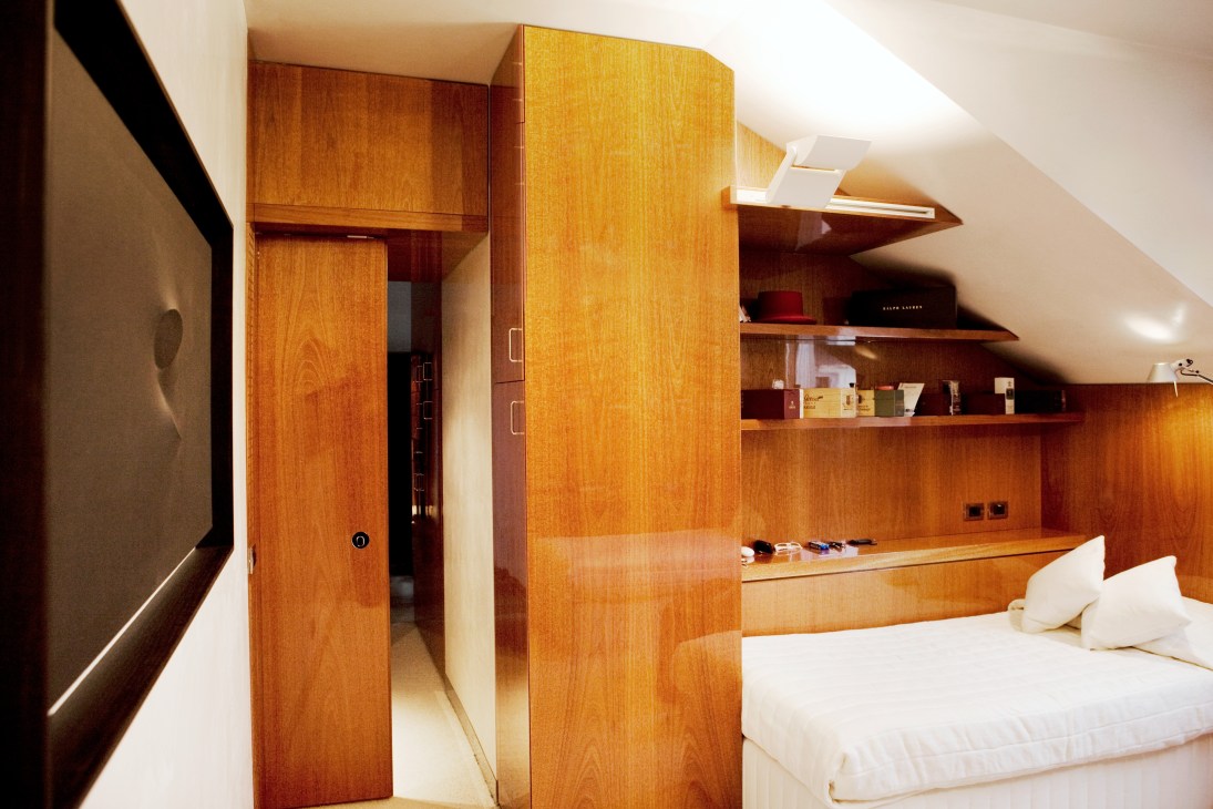 Attic bedroom with bespoke mahogany cabinetry and clever built-in storage solutions.