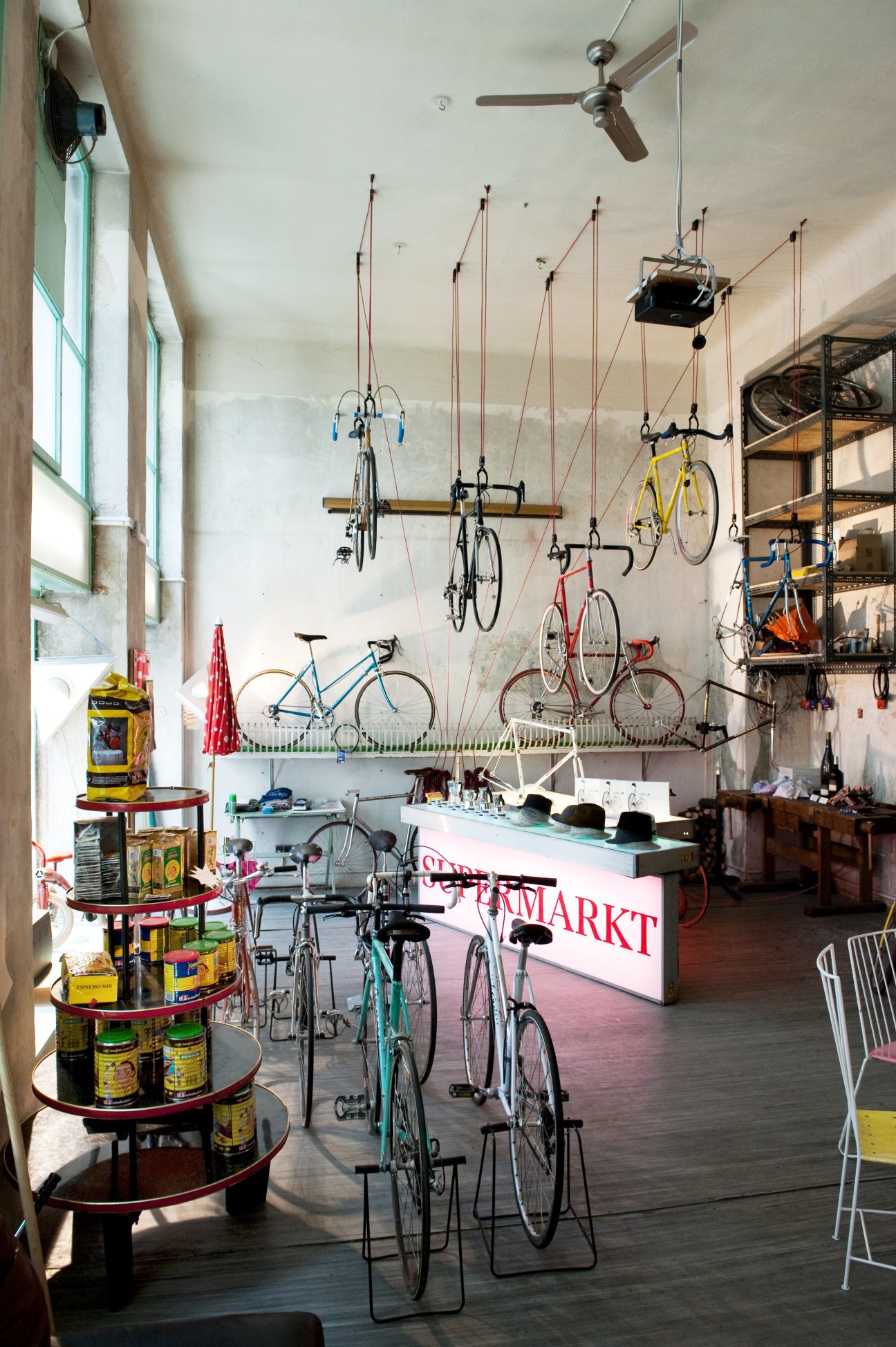 Interior of Radlager vintage bike shop with bicycles hanging from ceiling and displayed on floor.