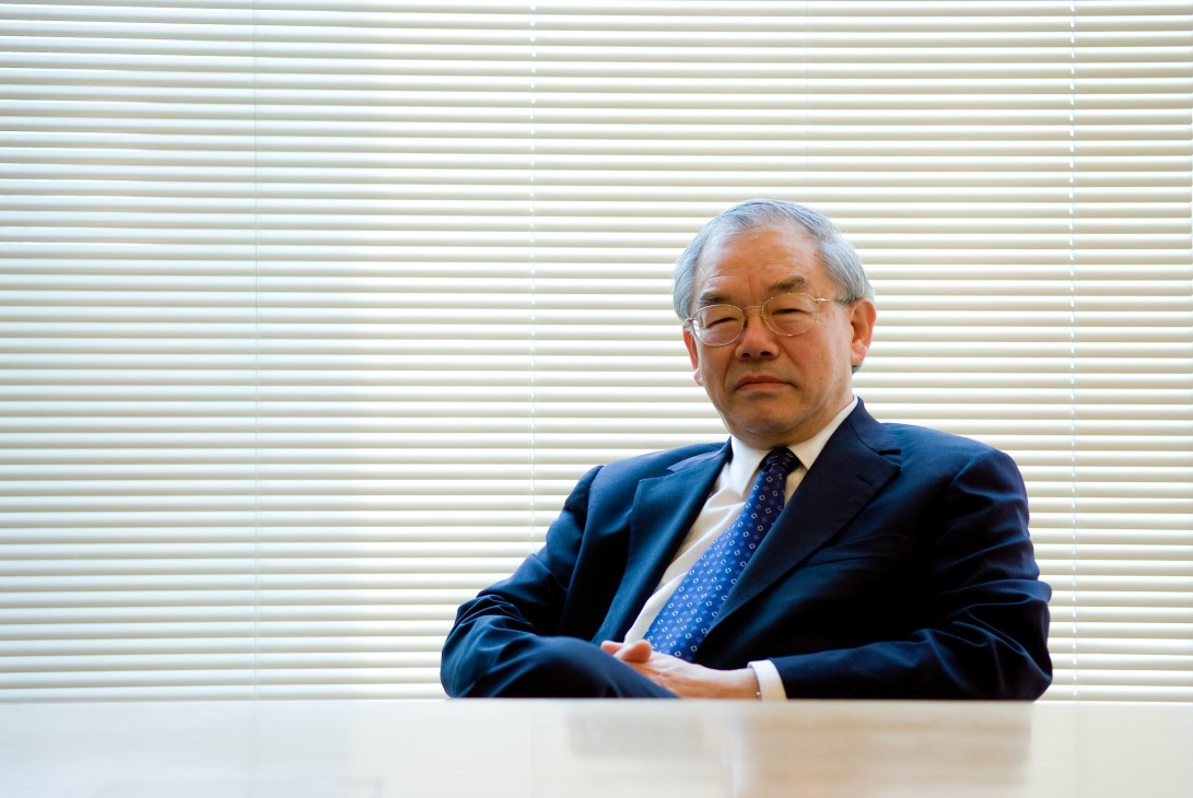 Nam-pyo Suh, KAIST president, seated at a table wearing a blue suit and patterned tie.