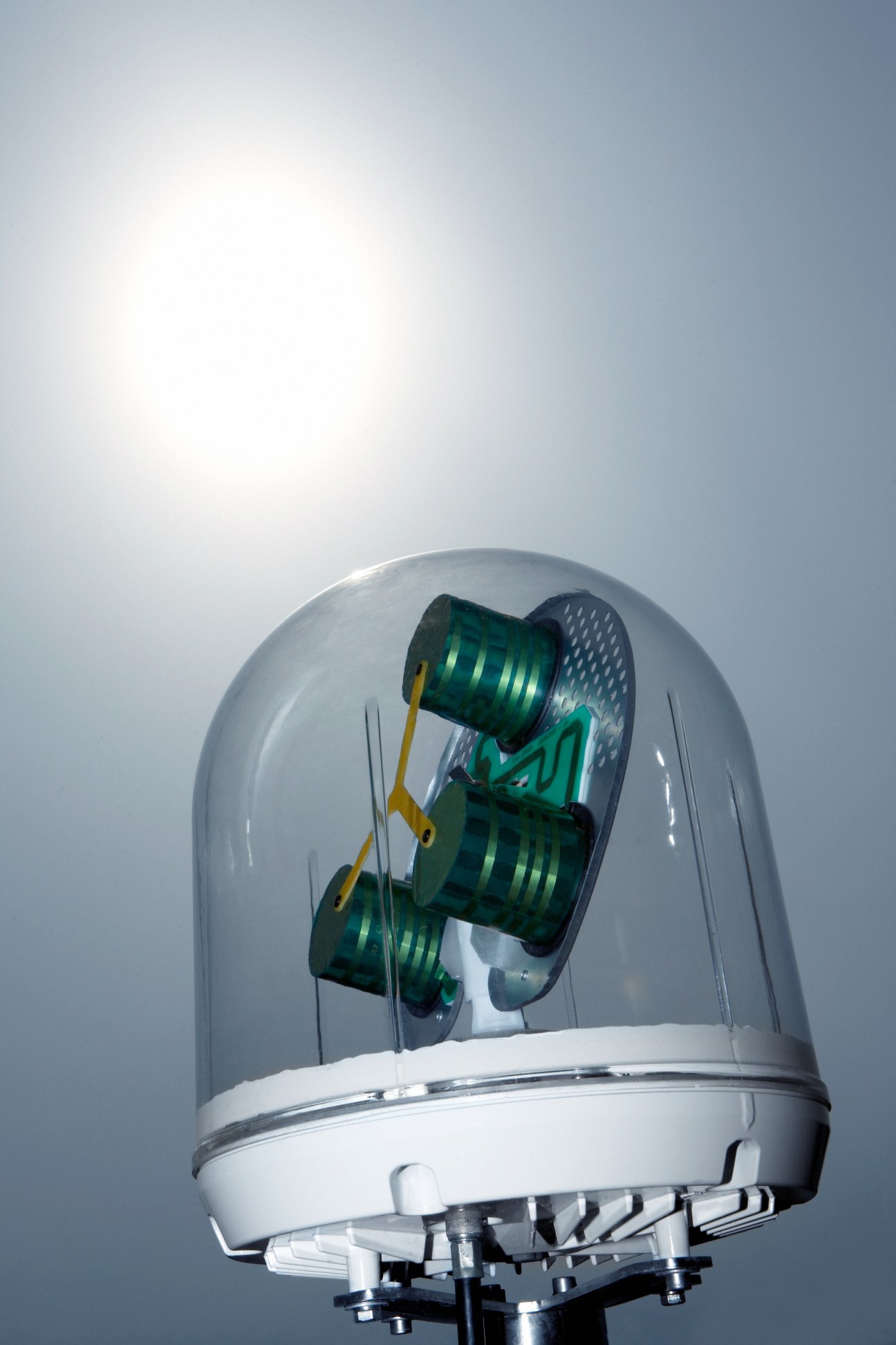 Sailor 250 antenna with green and yellow mechanical components inside a clear dome housing.