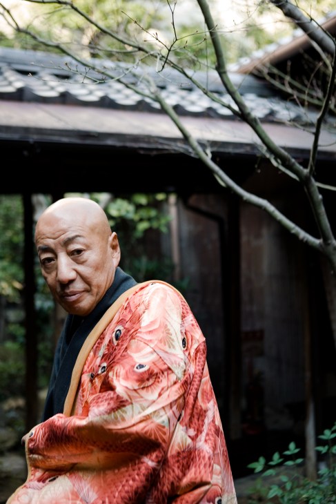 Genbei Yamaguchi wearing a red and cream patterned kimono at the Kondaya headquarters in Kyoto.