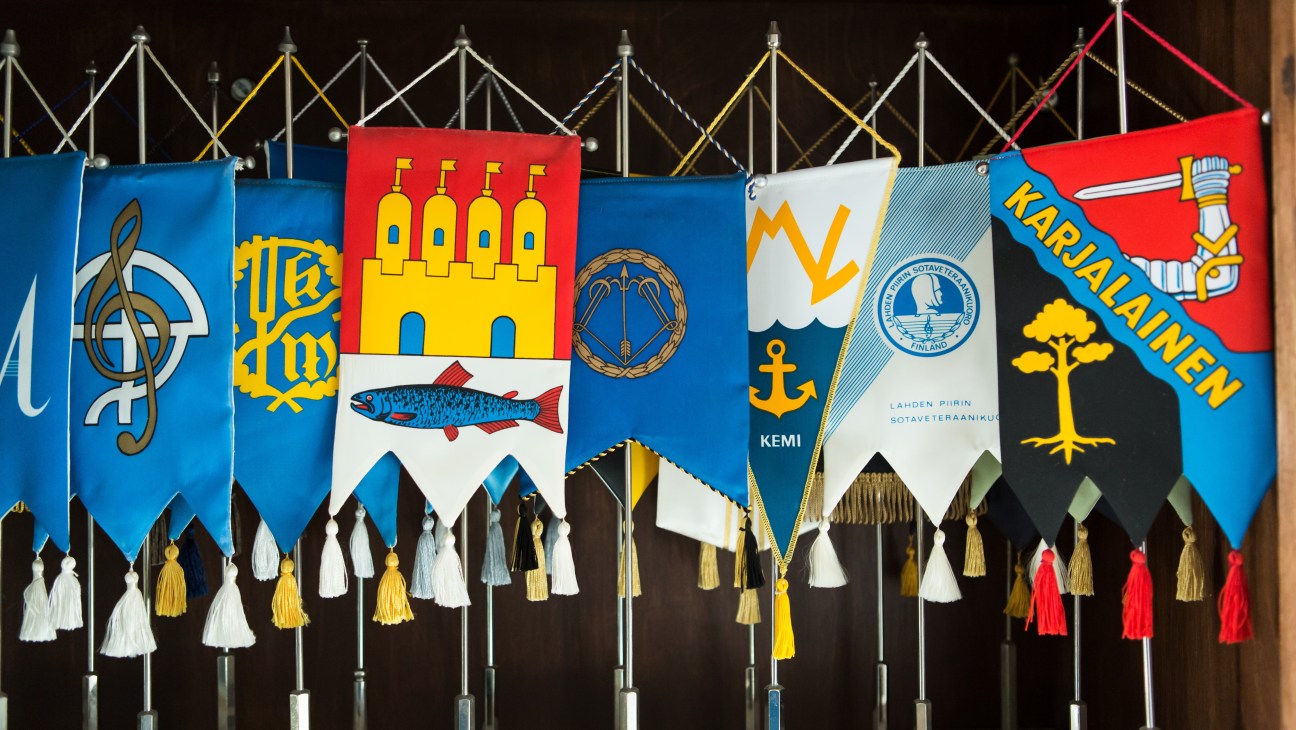 Decorative Finnish town and regional coats of arms hanging from poles at the Finlandia Club.