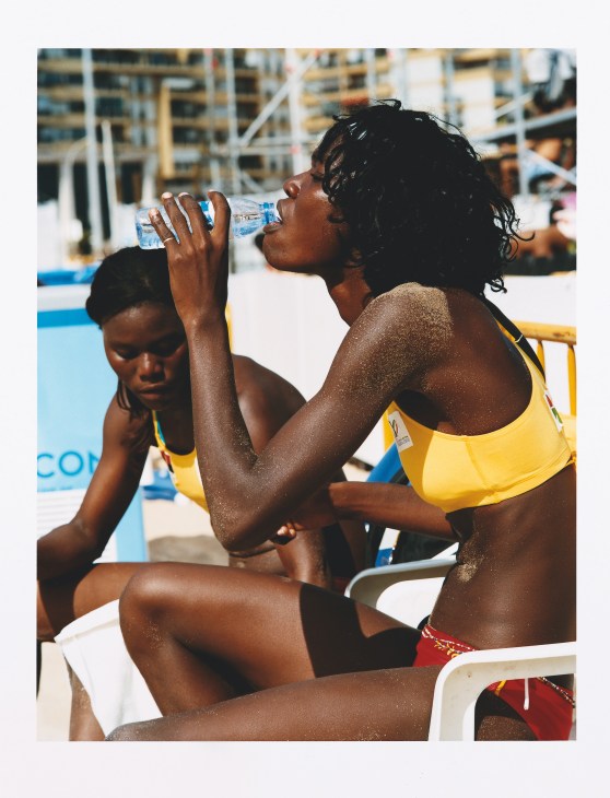 Angolan beach volleyball players Marlene Costa and Sara Kunga drinking water during a match at the Jogos da Lusofonia.