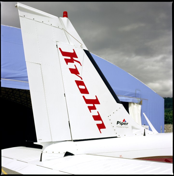 Tail section of a Piper aircraft with Krohn Air branding in red letters on white fuselage.