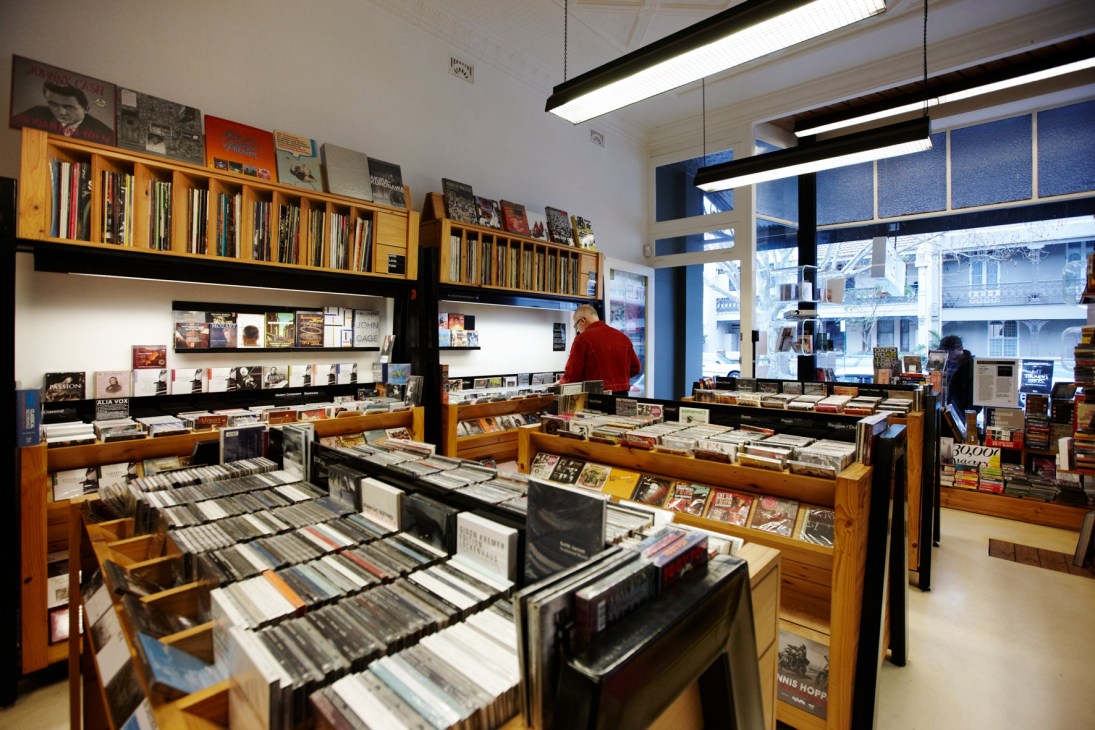 Interior of TITLE music and media store in Sydney with wooden shelving, CDs, vinyl records, and books organized in display cases.