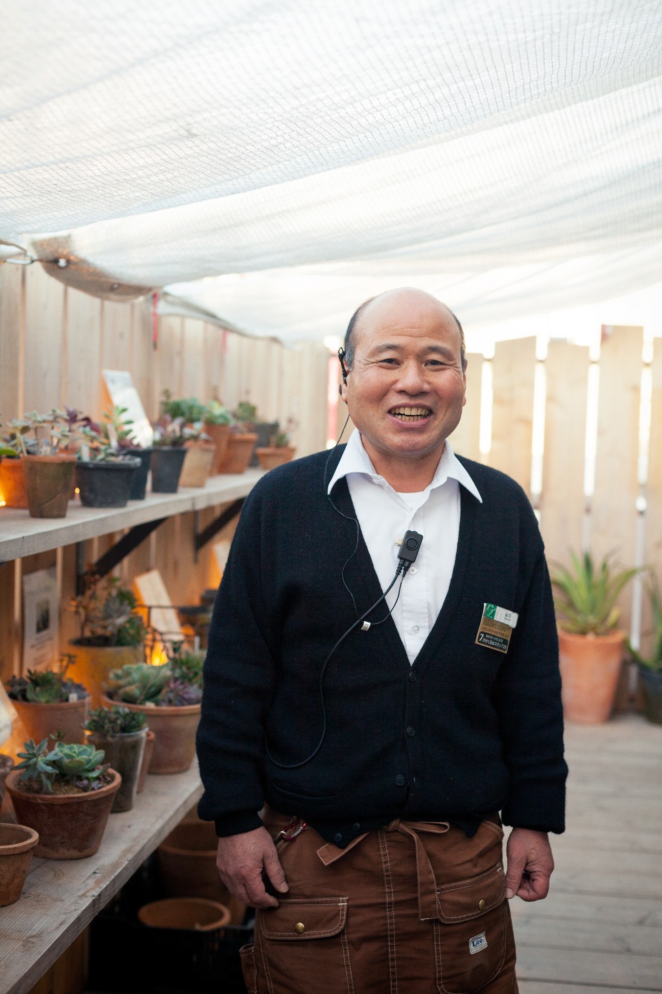 Hiroyuki Yamaguchi smiles while tending to potted succulents in Tokyu Hands' greenhouse.