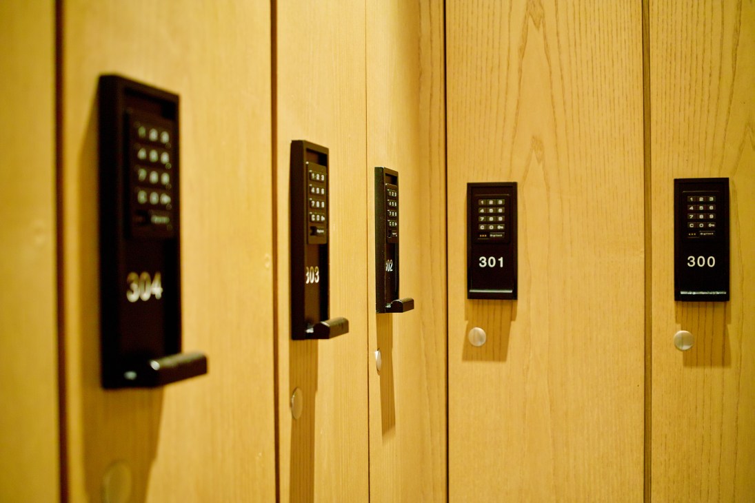 Hotel room doors with wooden paneling and electronic keypad locks displaying room numbers.