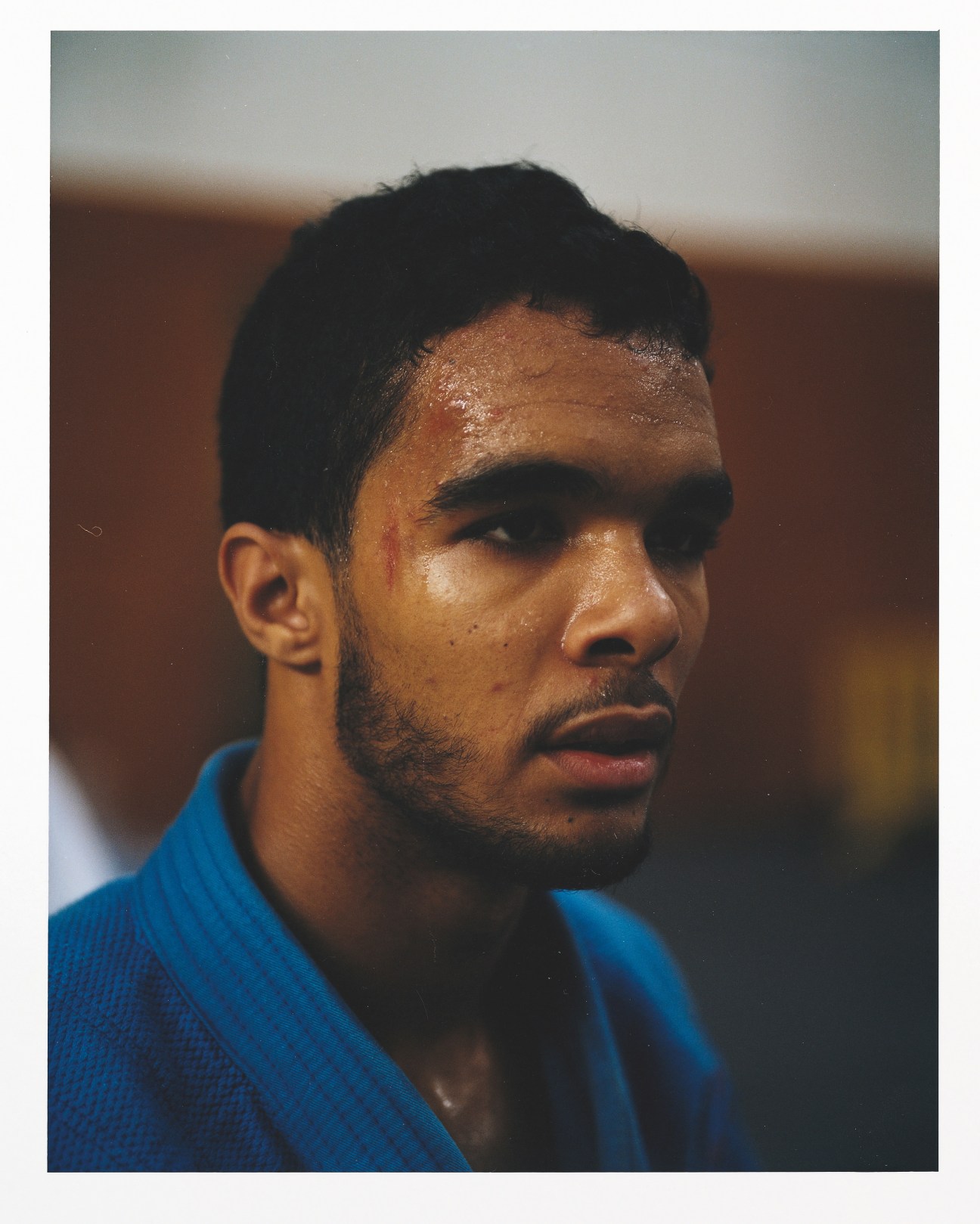 Male taekwondo athlete from Cape Verde in blue uniform with red mark on forehead.