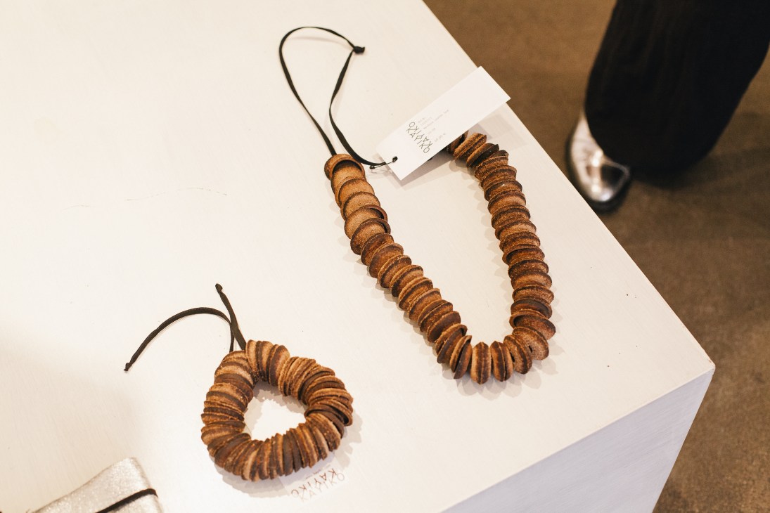 Two wooden beaded necklaces with black cord displayed on white cards at Kayiko boutique.