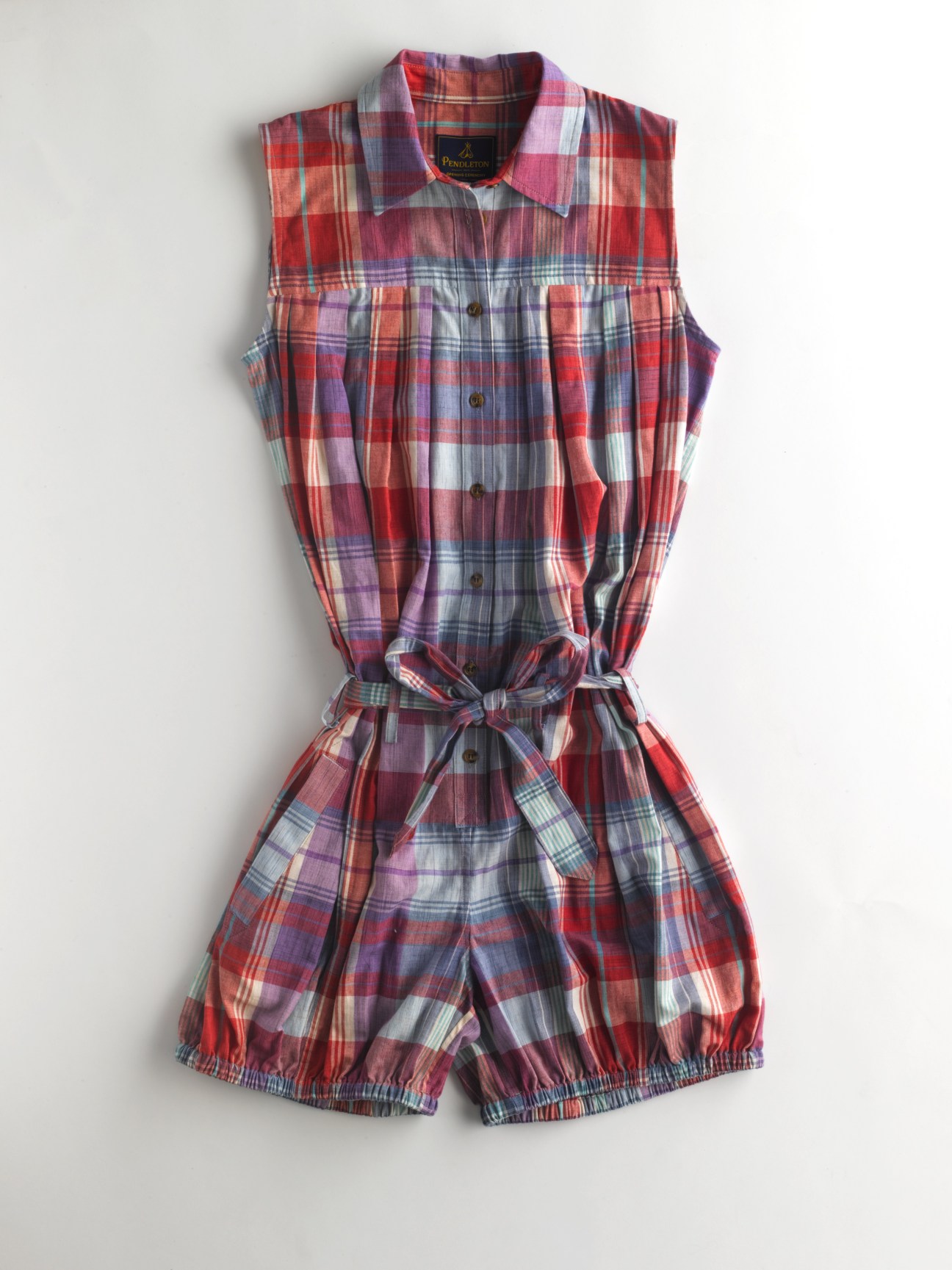 Pendleton plaid sleeveless shirt dress in red, purple, and blue madras pattern with button front and tied waist.