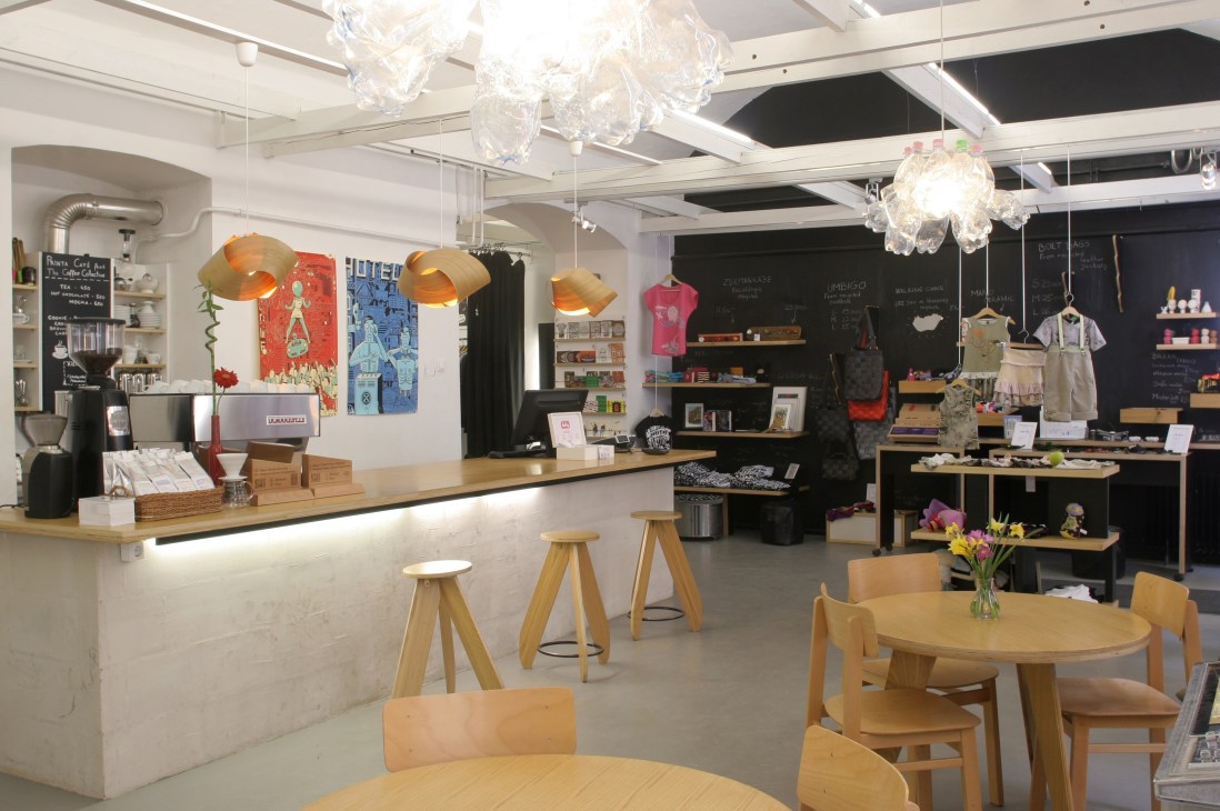 Interior of Printa concept store in Budapest showing cafe counter, gallery displays, and silkscreen studio space.