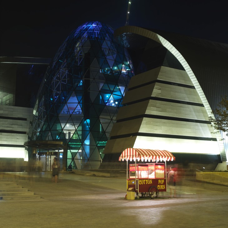 Nighttime view of modern architecture with a popcorn cart in front of Park Bulvar shopping centre in Baku.