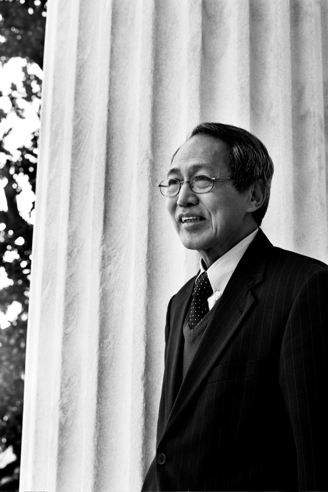 Dr Sein Win, Burmese prime minister-in-exile, poses in formal attire against draped curtains.