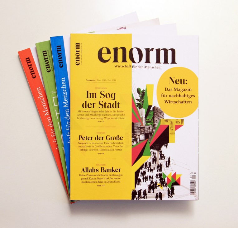 Stack of colorful Enorm magazine issues in red, green, blue and yellow with German text and graphics.