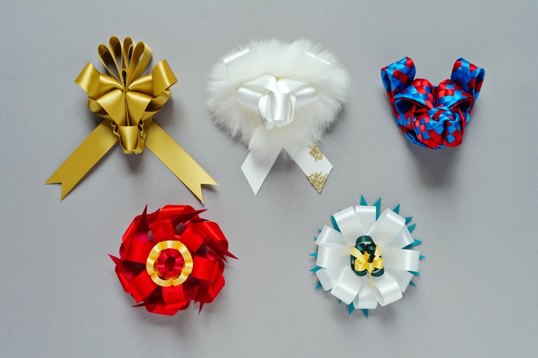 Five ribbon bows in various colors and styles displayed against a gray background.