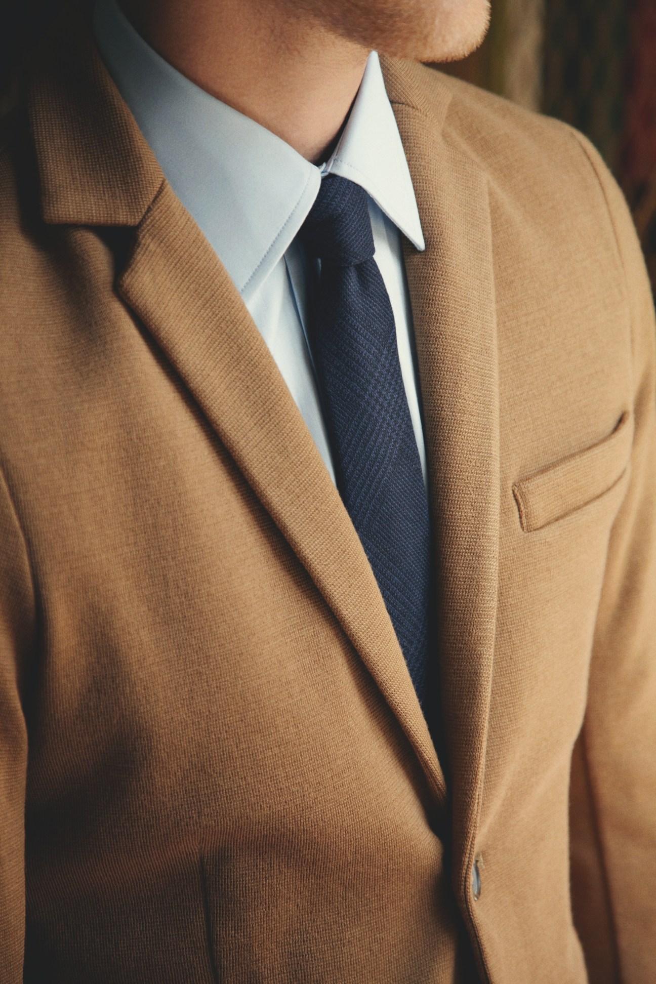 Man wearing a camel United Arrows jacket, white Dunhill shirt, and navy Brunello Cucinelli tie.