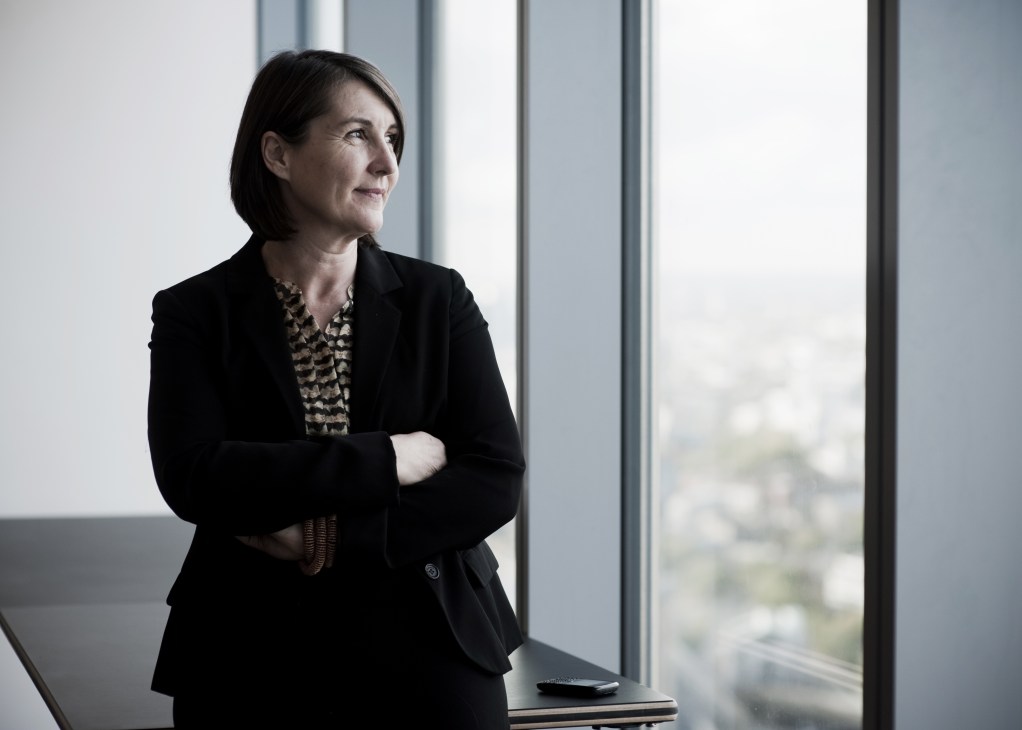 Kay Hughes, project sponsor and principal design adviser at the Olympic Delivery Authority, stands by a window in professional attire.