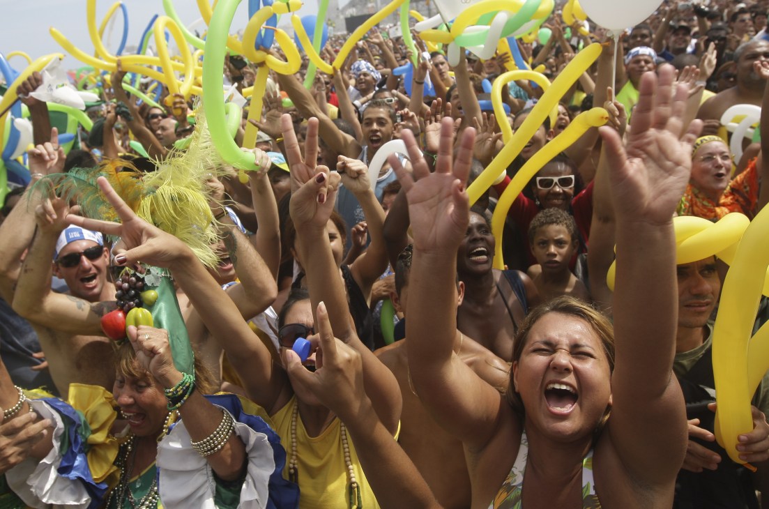 Brazilian supporters celebrate at a rally wearing yellow and green, the colors of the Brazilian flag.