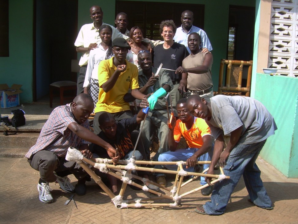 Group of workers in Ghana posing with a bamboo bicycle frame they constructed.