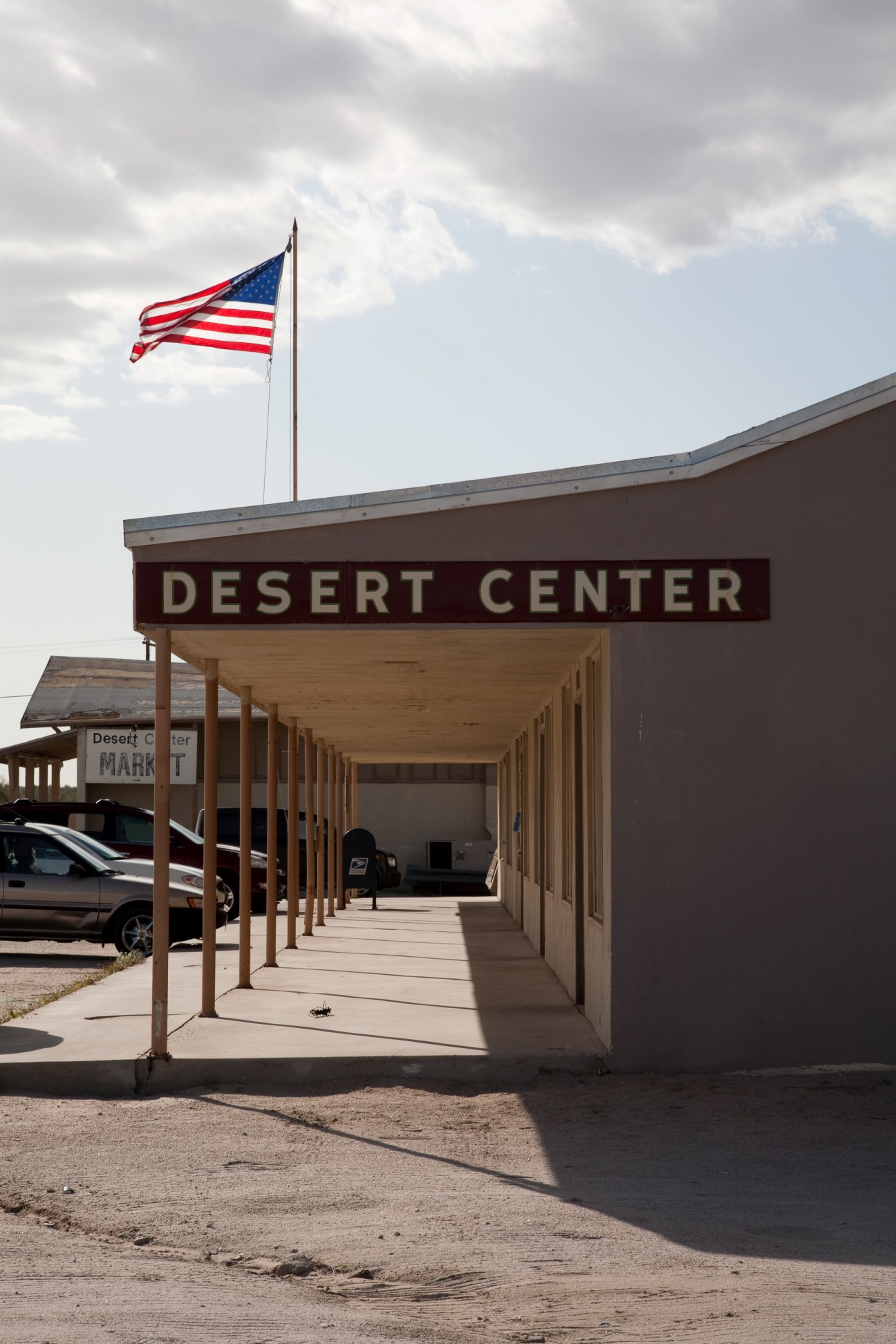 Desert Center town entrance with covered walkway, American flag, and market sign