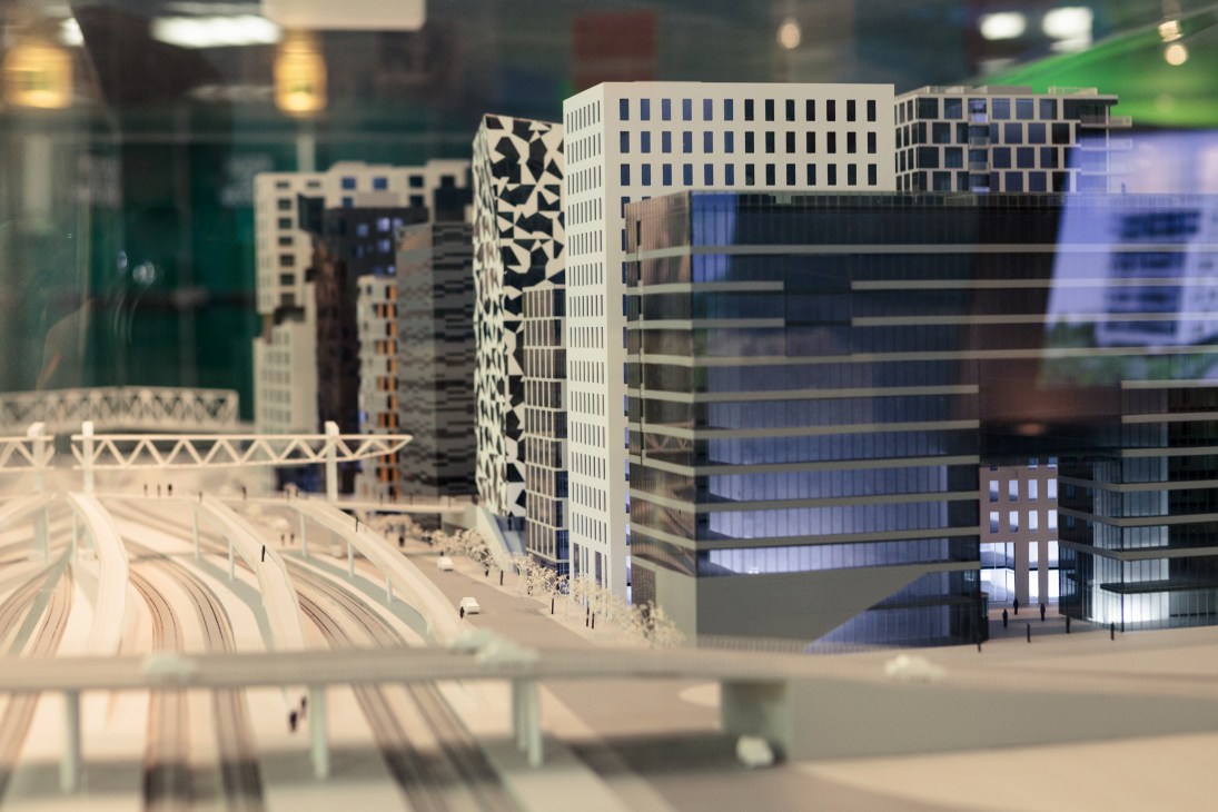Architectural model of the Opera Kvarteret project in Oslo featuring modern buildings with geometric patterns and blue-tinted glass facades.