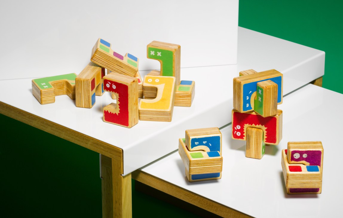 Cici hand-painted birch plywood blocks in various shapes and bright colors arranged on a white surface.