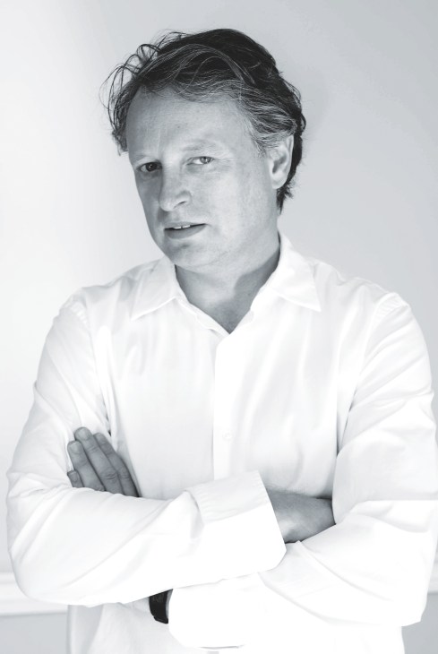 Black and white portrait of Ben Evans, Director of London Design Festival, wearing a white shirt with arms crossed.