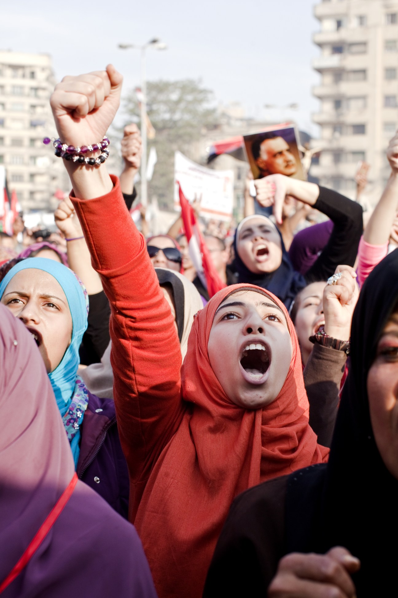 Activists with raised fists and Egyptian flags at a Tahrir Square protest during the 2011 Egyptian revolution