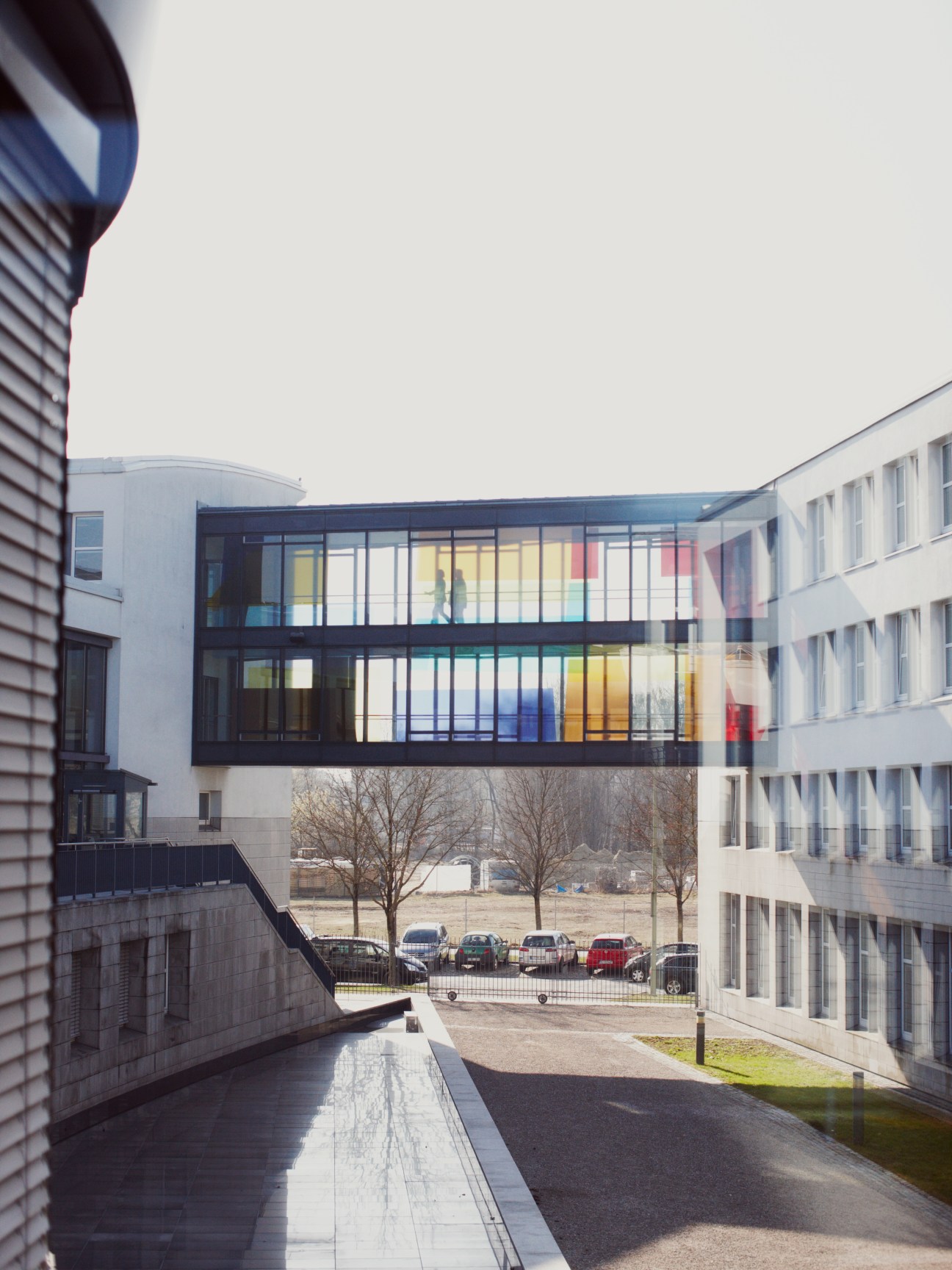 A modern corridor with glass walkway connecting buildings at Goethe-Institut Munich headquarters.