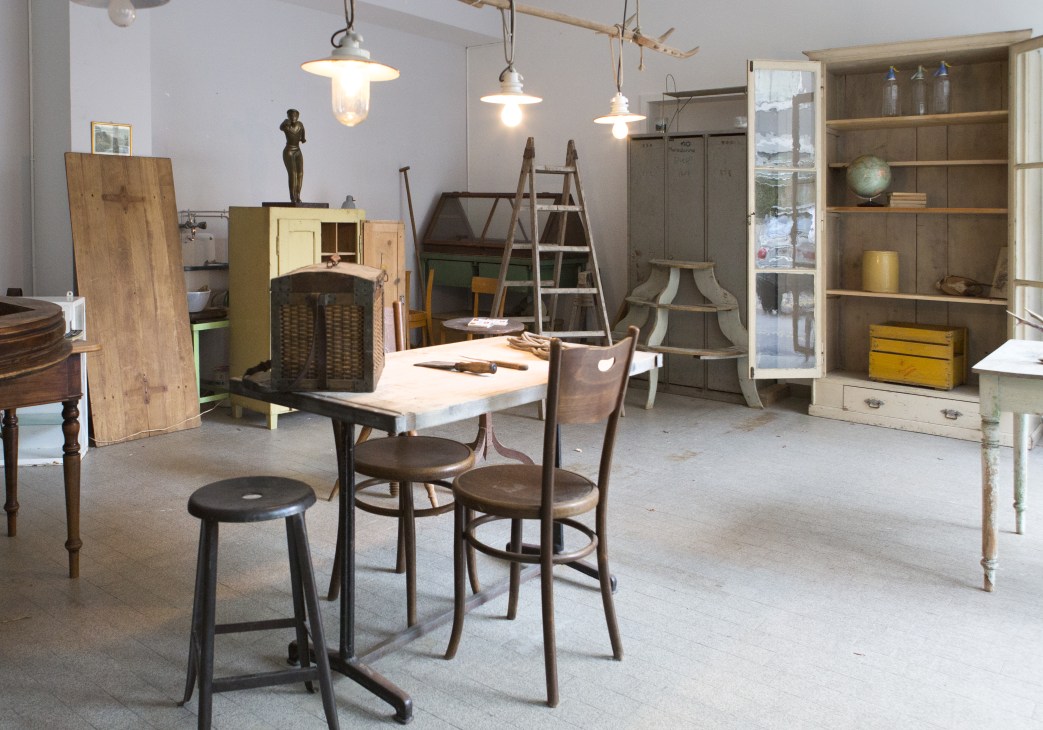 Interior of N°2 boutique in Zürich displaying vintage furniture, pendant lights, and eclectic décor items.
