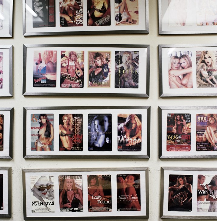 Framed DVD covers displayed on a white wall in an office setting.