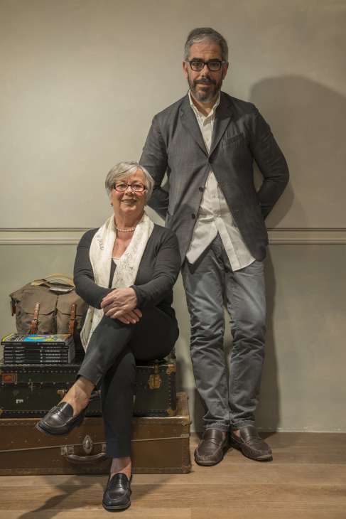 Two people posing with vintage suitcases in Biliardo store, Mirano.