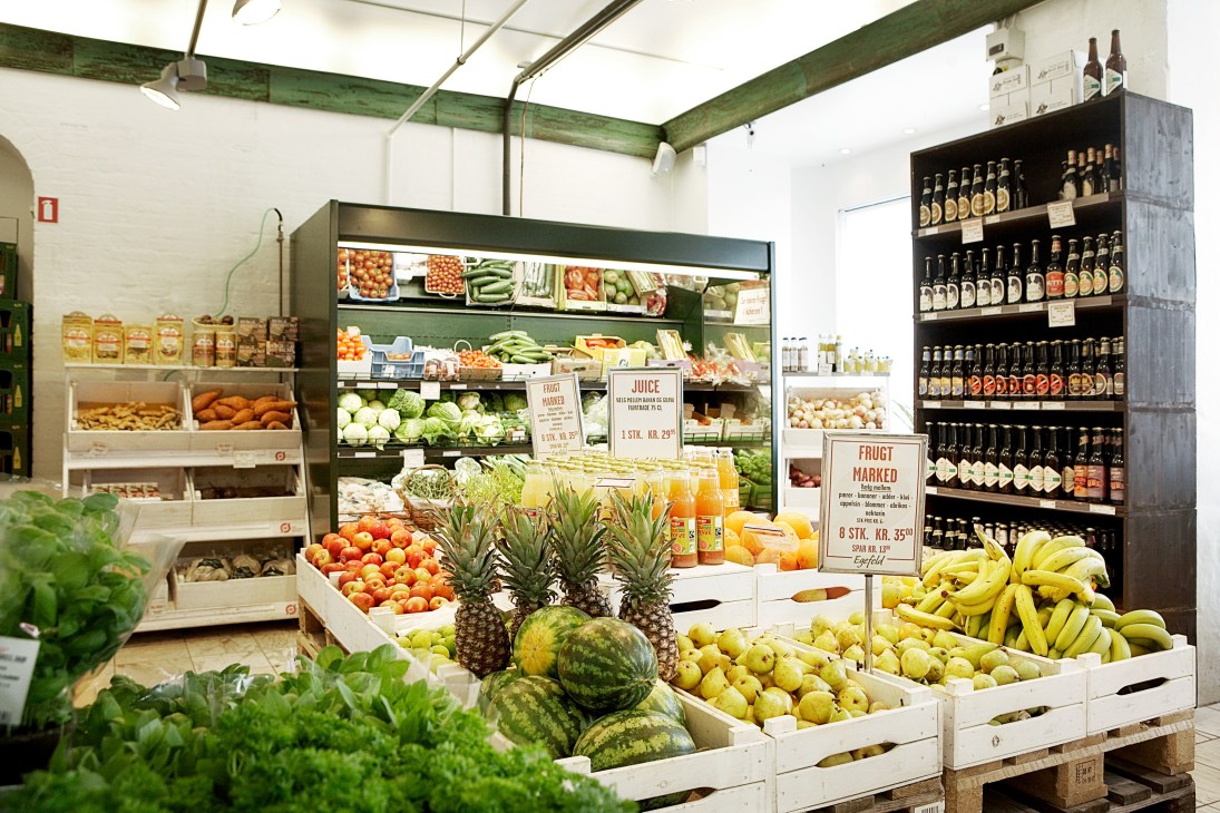 Interior of Egefeld organic market displaying fresh produce, juices, and bottled goods on shelves.