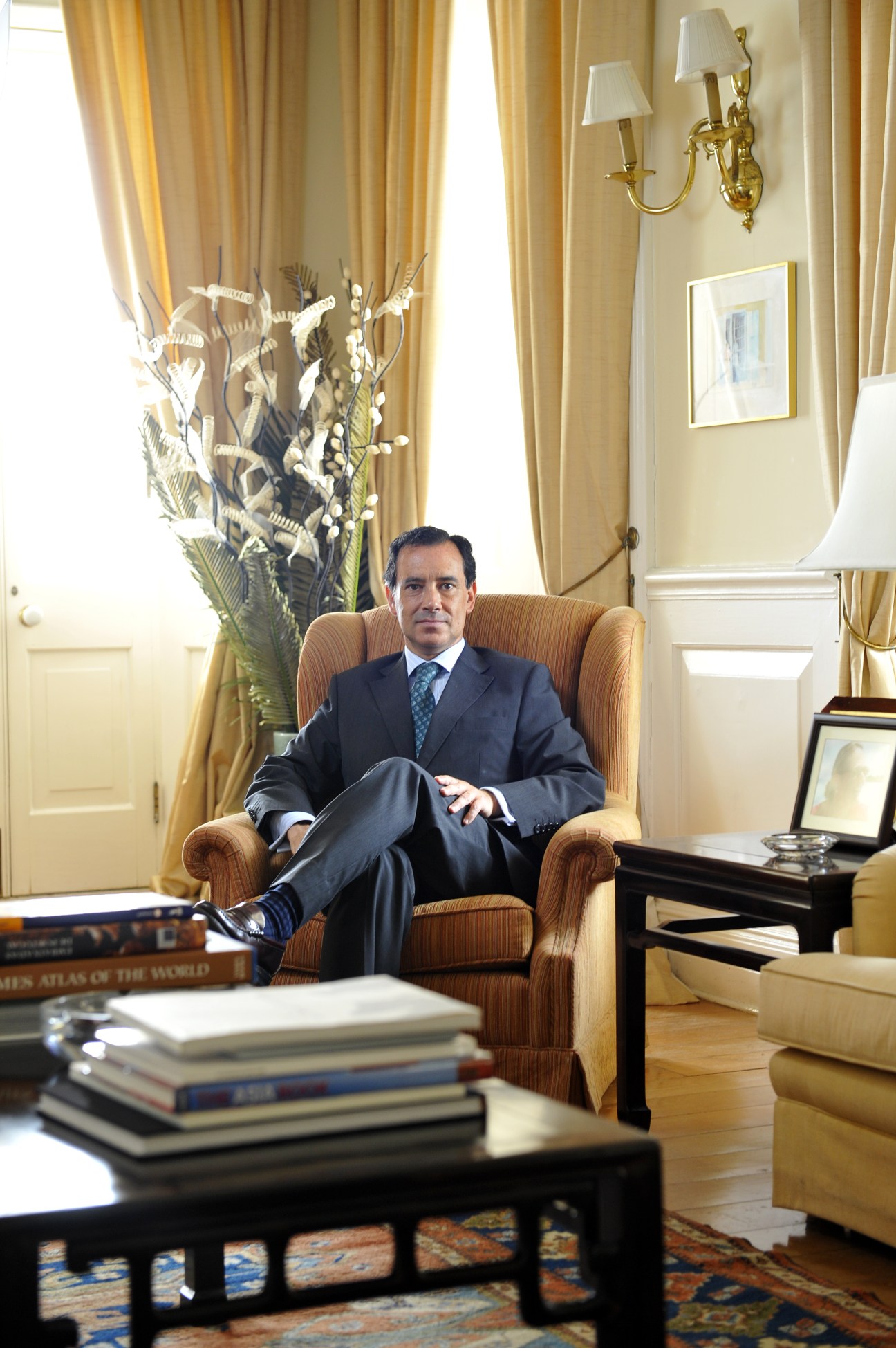 Portuguese consul Manuel Carvalho seated in an elegant armchair in a formally decorated office.