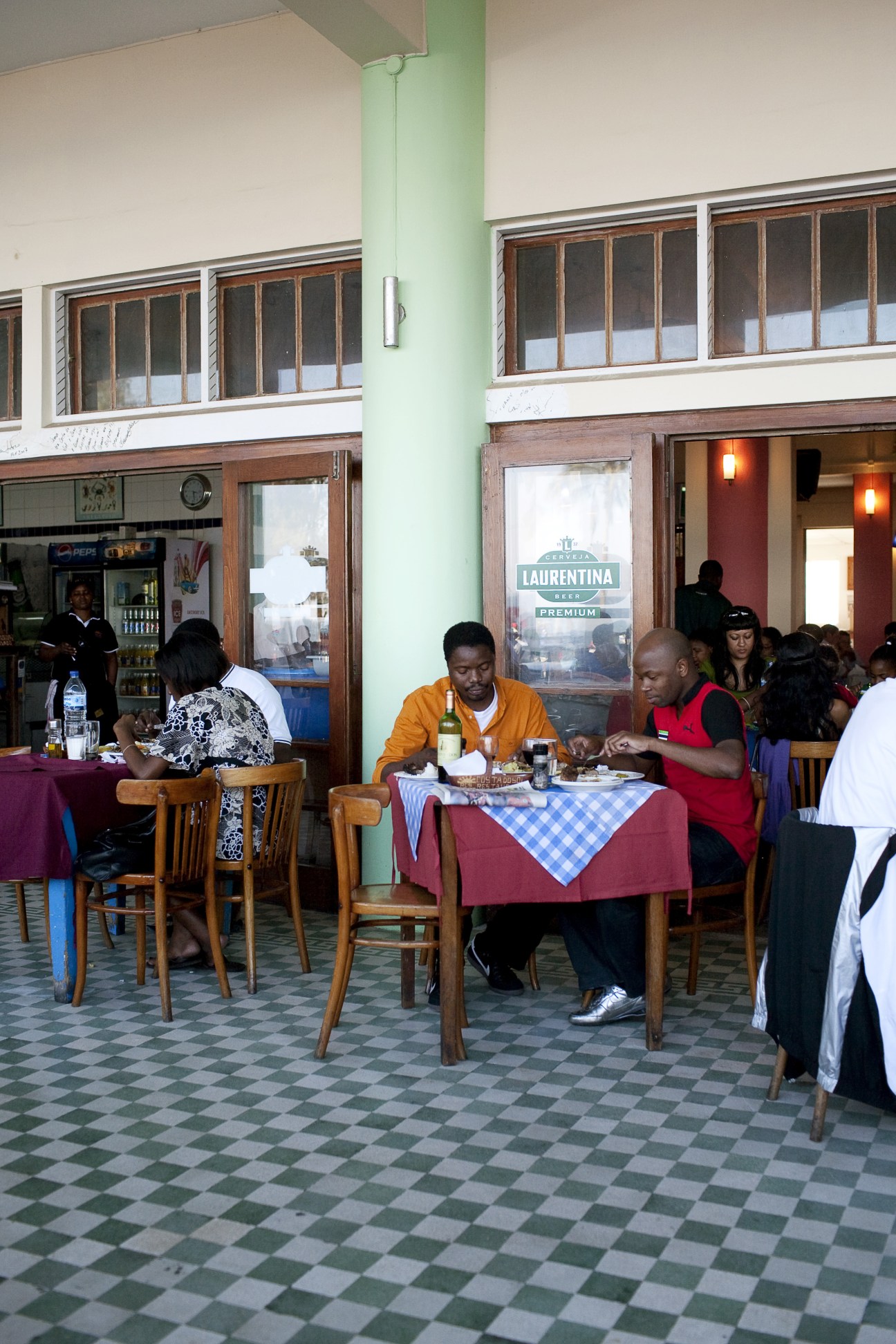 Interior of Costa del Sol restaurant with diners seated at tables with checkered tablecloths.