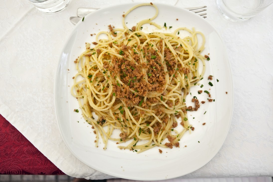 Pasta alla bottarga with tuna roe, olive oil, garlic and lemon peel garnished with fresh herbs.